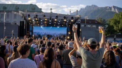 Menschenmenge mit erhobenen Händen vor beleuchteter Bühne beim Bridge Beat Festival in Innsbruck