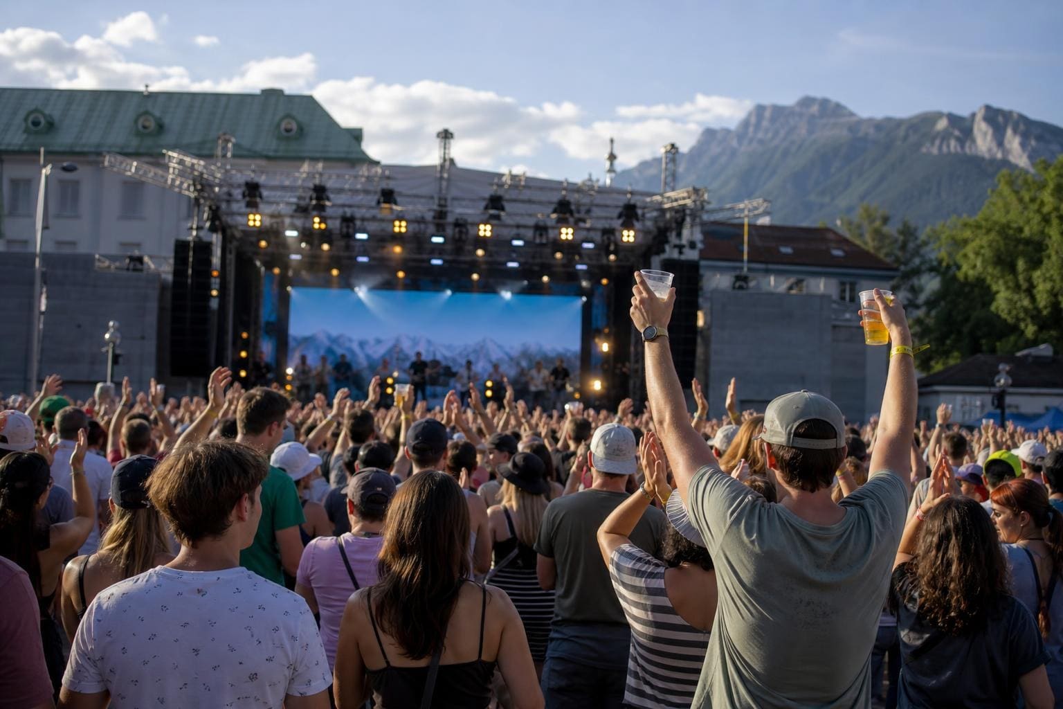 Menschenmenge mit erhobenen Händen vor beleuchteter Bühne beim Bridge Beat Festival in Innsbruck
