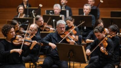 Orchestermusiker mit Geigen beim Konzert im Saal von Villach