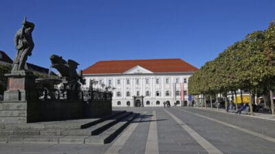 Drachenbrunnen auf dem Neuen Platz vor dem Rathaus in Klagenfurt unter blauem Himmel
