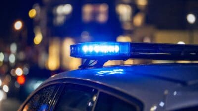 Blaues Blinklicht auf dem Dach eines Polizeifahrzeugs bei Nacht