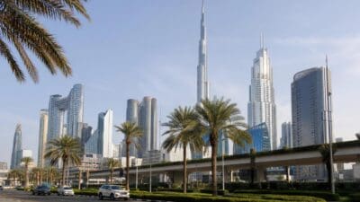 Skyline von Dubai mit dem Burj Khalifa, modernen Hochhäusern und Palmen an einer Autobahn