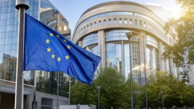 Blaue Flagge der Europäischen Union weht vor modernen Glasgebäuden