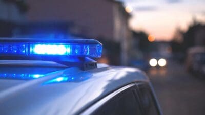 Blaues Blaulicht leuchtet auf dem Dach eines Polizeifahrzeugs bei Dämmerung