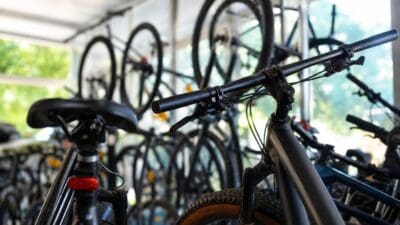 Mountainbikes im Vordergrund, weitere Fahrräder hängen an der Wand eines Ladens