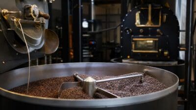 Kaffeeröstmaschine mit gerösteten Bohnen und Rührwerk in einem großen Metallbehälter