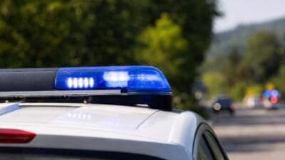 Blaues Blaulicht auf dem Dach eines weißen Polizeifahrzeugs