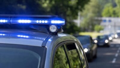 Blaues Blaulicht auf dem Dach eines Polizeiautos an einer Straße