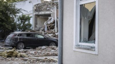 Zerstörtes Gebäude mit zerbrochenem Fenster, Trümmern und beschädigtem Auto nach Gasexplosion