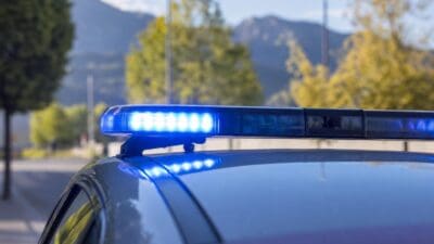 Aktivierte blaue Blaulichter auf dem Dach eines Einsatzfahrzeugs vor Berglandschaft im Hintergrund