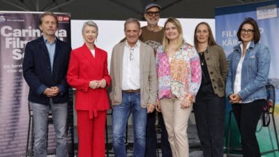 Sieben Personen posieren vor Bannern der Carinthia Film Commission in Klagenfurt