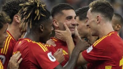 Spanische Fußballspieler in roten Trikots umarmen sich und feiern den Sieg.