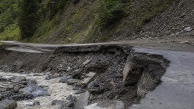 Eingestürzte Straßenböschung neben reißendem Fluss nach Unwetter im Navistal