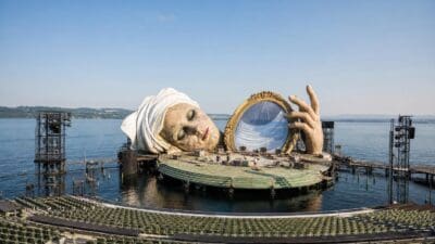 Bühneninstallation mit riesigem Kopf und Hand auf der schwimmenden Seebühne des Bodensees in Bregenz
