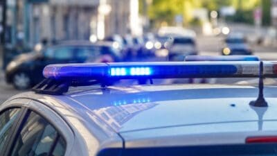 Blaues Blaulicht leuchtet auf dem Dach eines Polizeiautos in Wien.