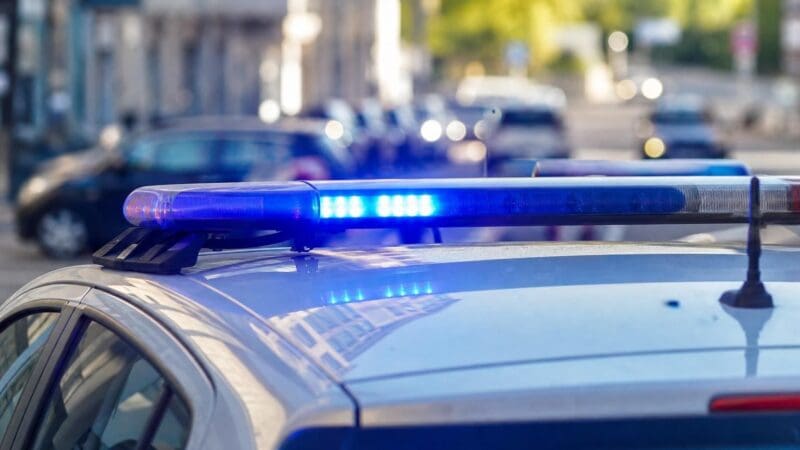 Blaues Blaulicht leuchtet auf dem Dach eines Polizeiautos in Wien.