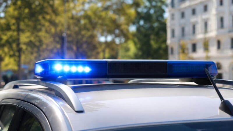Blaulichtbalken auf dem Dach eines Polizeifahrzeugs mit leuchtendem blauen Licht