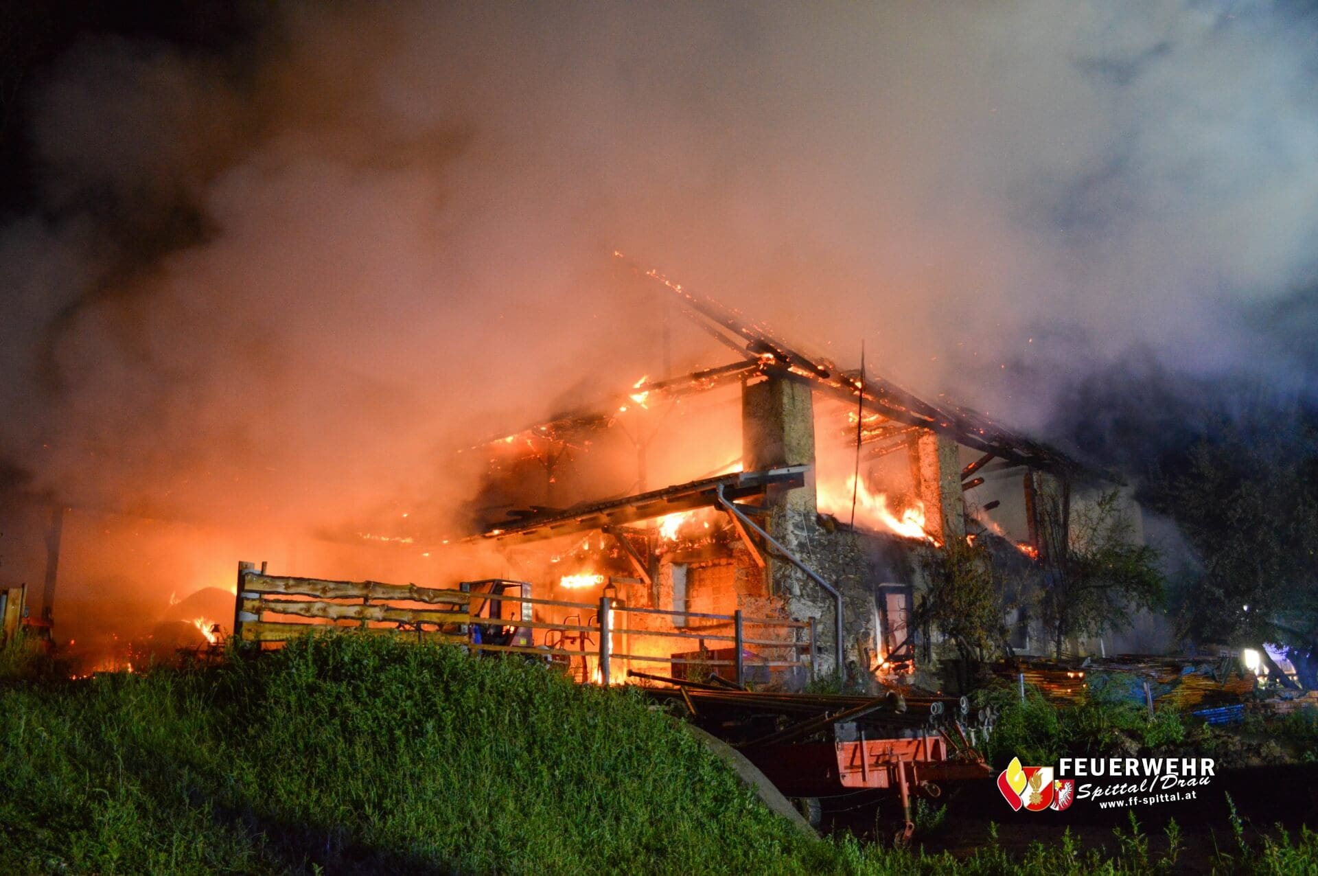 Ein Wirtschaftsgebäude steht bei Nacht in Vollbrand mit großen Flammen und dichter Rauchwolke.