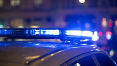 Blaues Blaulicht leuchtet auf dem Dach eines Polizeifahrzeugs bei Nacht