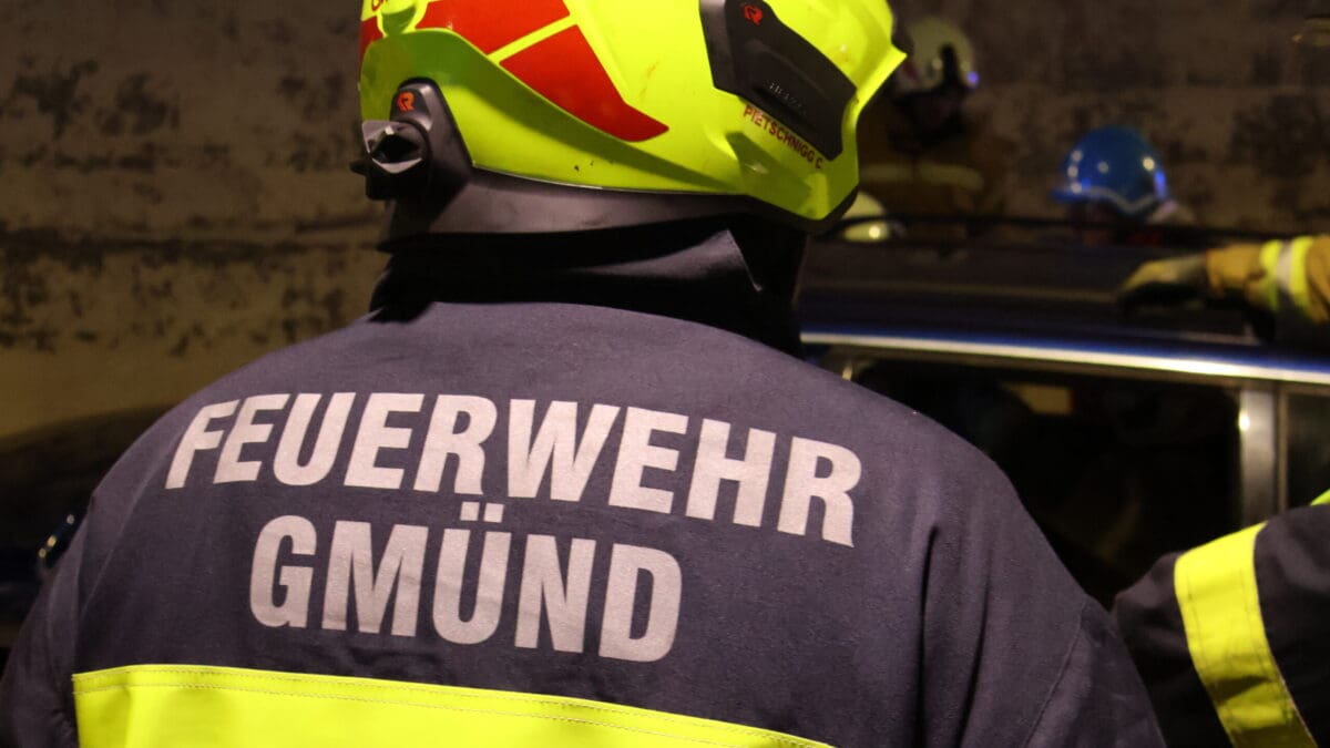Rückenansicht eines Feuerwehrmanns mit gelbem Helm und Jacke der Feuerwehr Gmünd
