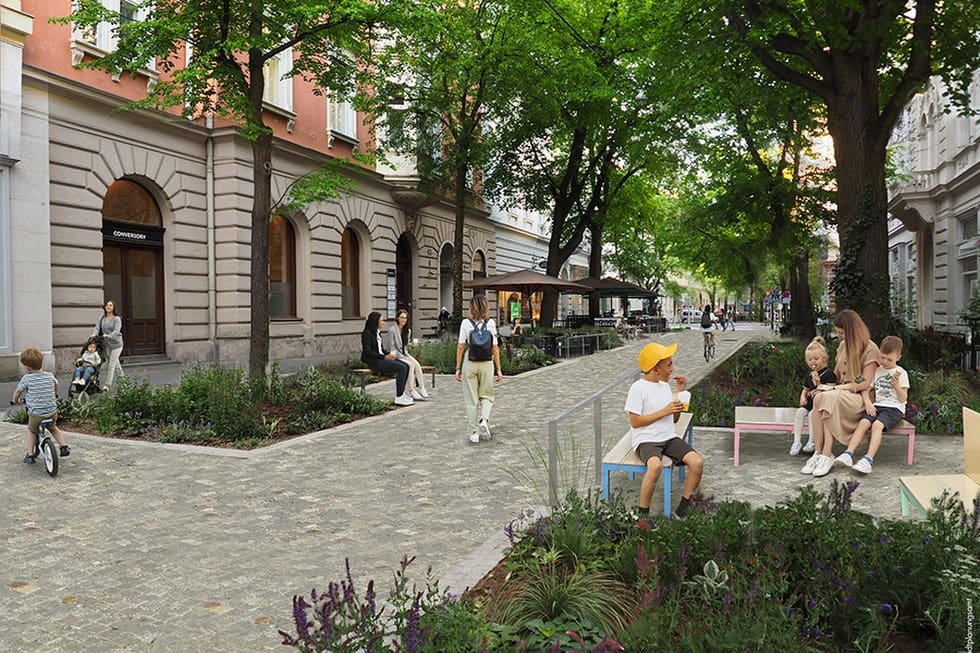 Menschen sitzen und gehen auf der Kaiserfeldgasse in Graz zwischen Bäumen und historischen Häusern