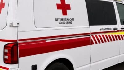 Nahaufnahme der Seitenfläche eines weißen Rettungswagens mit rotem Kreuz und Aufschrift des Österreichischen Roten Kreuzes