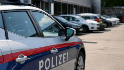 Österreichisches Polizeiauto mit Blaulicht und Aufschrift Polizei auf einem Parkplatz