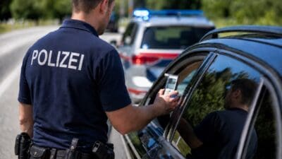 Polizist in Uniform führt einen Atemalkoholtest durch das Fenster eines Autos durch