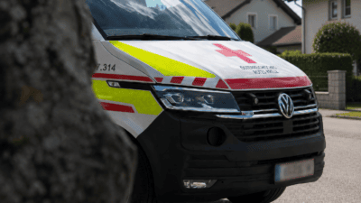 Front eines weißen Rettungsfahrzeugs des Österreichischen Roten Kreuzes mit rotem Kreuzsymbol und gelb-roten Markierungen.