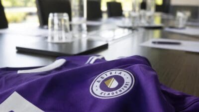 Lila Trikot von Austria Klagenfurt mit Logo auf einem Konferenztisch in einem Besprechungsraum