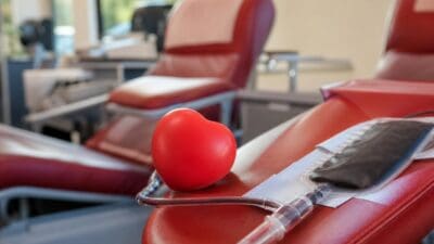 Rote Blutspende-Liegen mit einem Herzball und einem Blutbeutel im Vordergrund.
