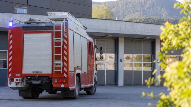 Rotes Feuerwehrfahrzeug mit Blaulicht vor der Feuerwache in Jenbach