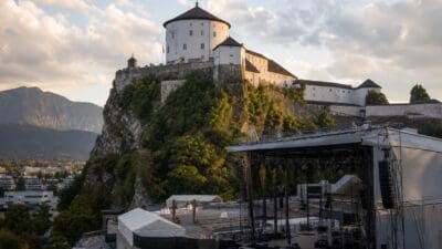 Große Konzertbühne mit Gerüsten und Zelten vor der weißen Festung auf einem Felsen
