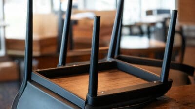 Die Unterseite eines umgedrehten schwarzen Stuhls mit Holzplatte und Beinen in einem Restaurant