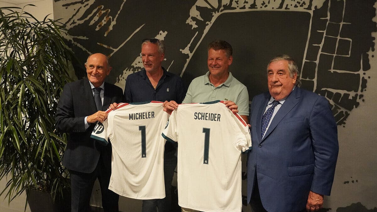 Vier Männer präsentieren zwei personalisierte Real-Trikots mit den Namen Micheler und Scheider.