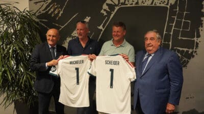Vier Männer präsentieren zwei personalisierte Real-Trikots mit den Namen Micheler und Scheider.