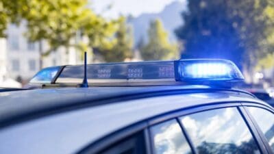 Das blaue Blaulicht eines Polizeifahrzeugs leuchtet auf dem Dach des Autos.
