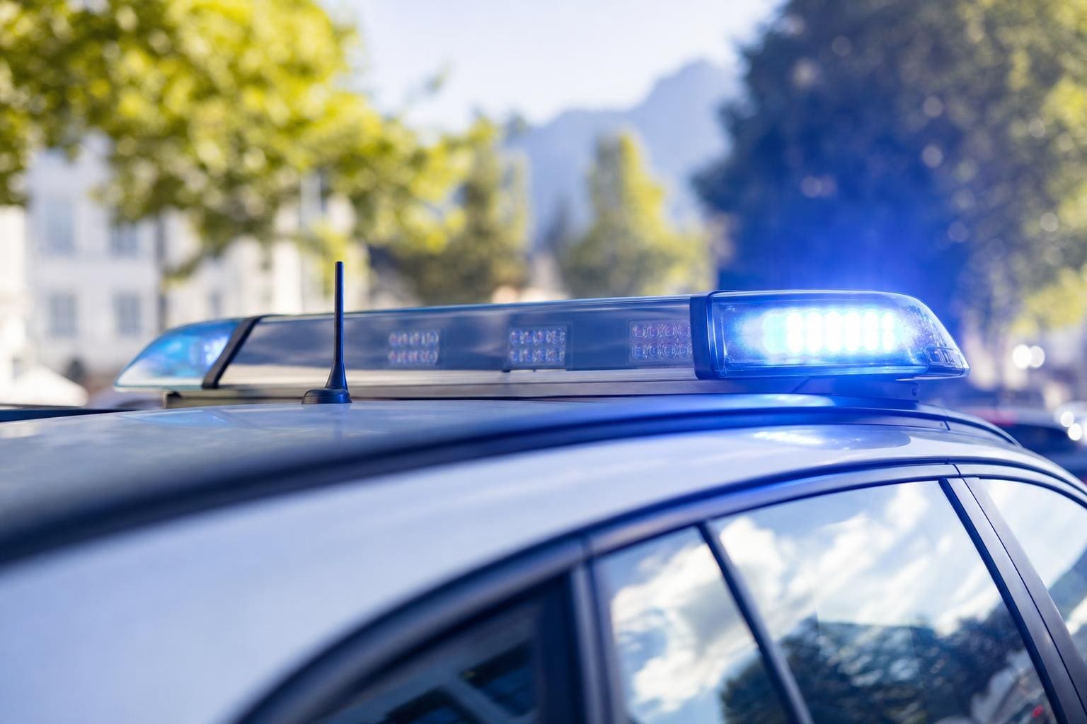 Das blaue Blaulicht eines Polizeifahrzeugs leuchtet auf dem Dach des Autos.