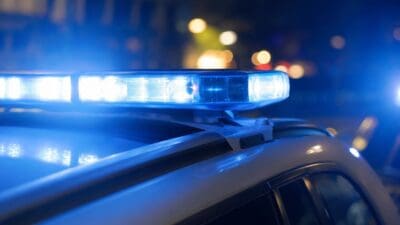 Nahaufnahme eines blauen Blaulichts auf dem Dach eines Polizeifahrzeugs bei Nacht