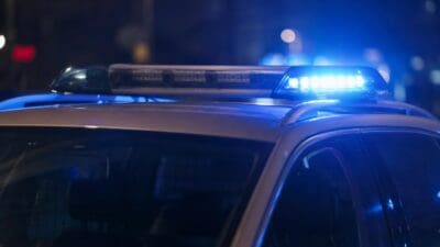 Polizeifahrzeug mit blauem Blaulicht auf dem Dach bei Nacht
