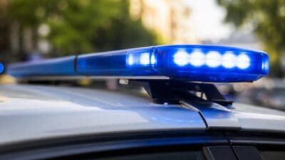 Aktiviertes blaues Blinklicht mit vier leuchtenden LED-Lampen auf dem Dach eines Polizeifahrzeugs