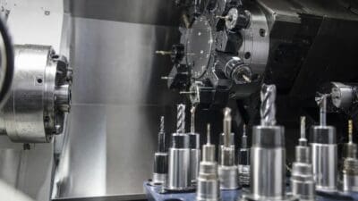 Innenansicht einer CNC-Maschine mit zahlreichen Werkzeughaltern und Fräswerkzeugen im Vordergrund.