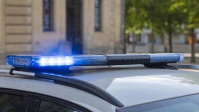Blaues Blaulicht leuchtet auf dem Dach eines Polizeifahrzeugs.