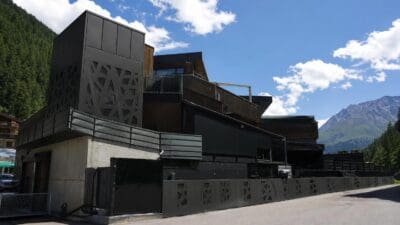 Modernes dunkles Gebäude mit geometrischer Metallfassade vor Bergkulisse in Sölden