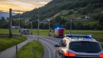 Einsatzfahrzeuge der Feuerwehr und Polizei mit Blaulicht auf der B171 an einem Bahnübergang.
