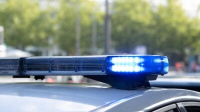 Nahaufnahme eines blauen Blaulichts auf dem Dach eines Polizeifahrzeugs vor unscharfem Hintergrund