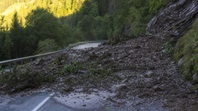 Mit Schlamm und Geröll bedeckte Fahrbahn der L27 bei Boden nach einer Mure