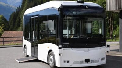 Weiß-schwarzer autonomer E-Bus mit ausgefahrener Rampe in Berglandschaft bei Alpbach