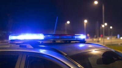 Blaues und rotes Blinklicht auf dem Dach eines Polizeifahrzeugs bei Nacht