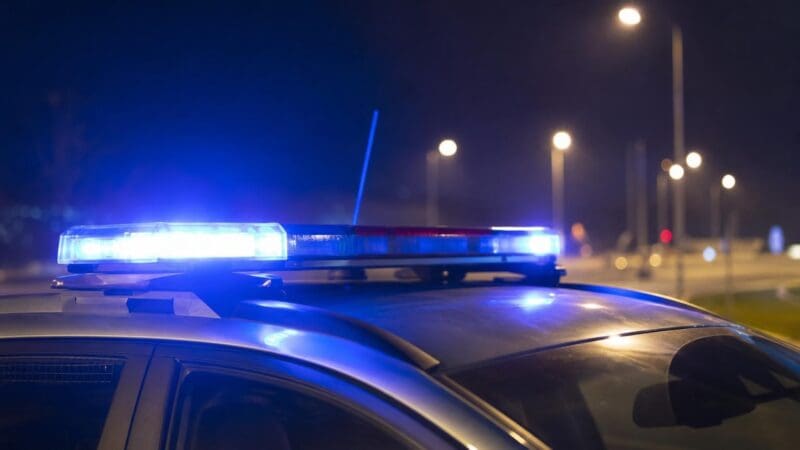 Blaues und rotes Blinklicht auf dem Dach eines Polizeifahrzeugs bei Nacht